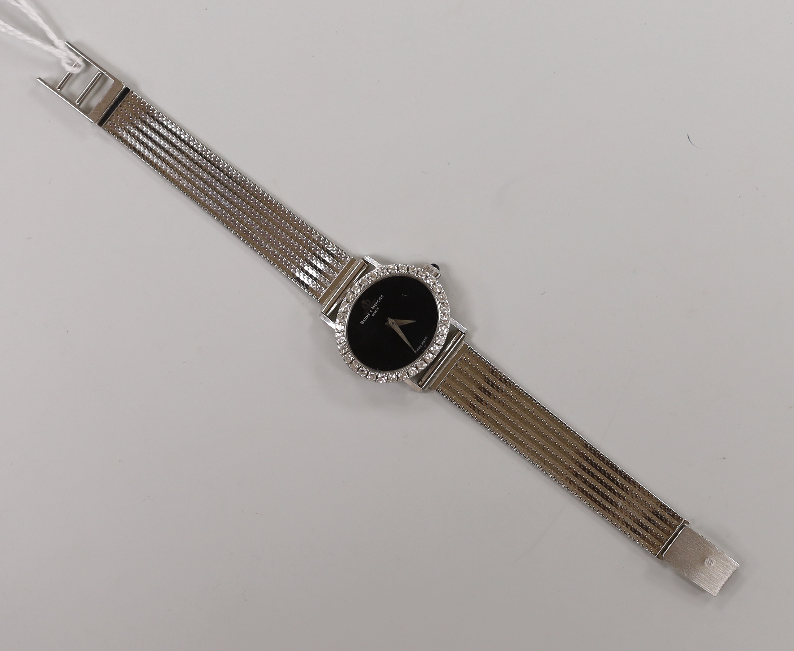 A lady's Baume & Mercier 750 white metal and diamond set manual wind dress wrist watch, with black oval dial, overall 17cm, gross weight 37.5 grams.